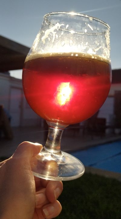 a ruby coloured beer at sunset