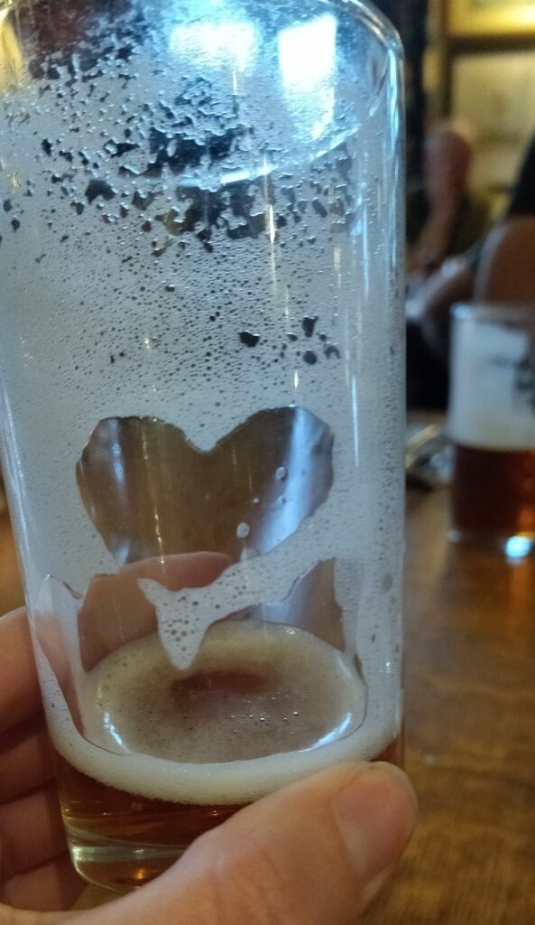 a beer glass with heart in the foam